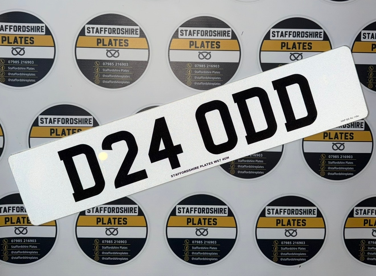 White D24 ODD custom number plate on branded sticker background